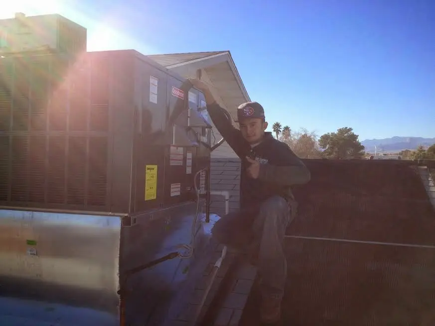 HVAC technician performing HVAC Inspection on a rooftop unit in Norfolk
